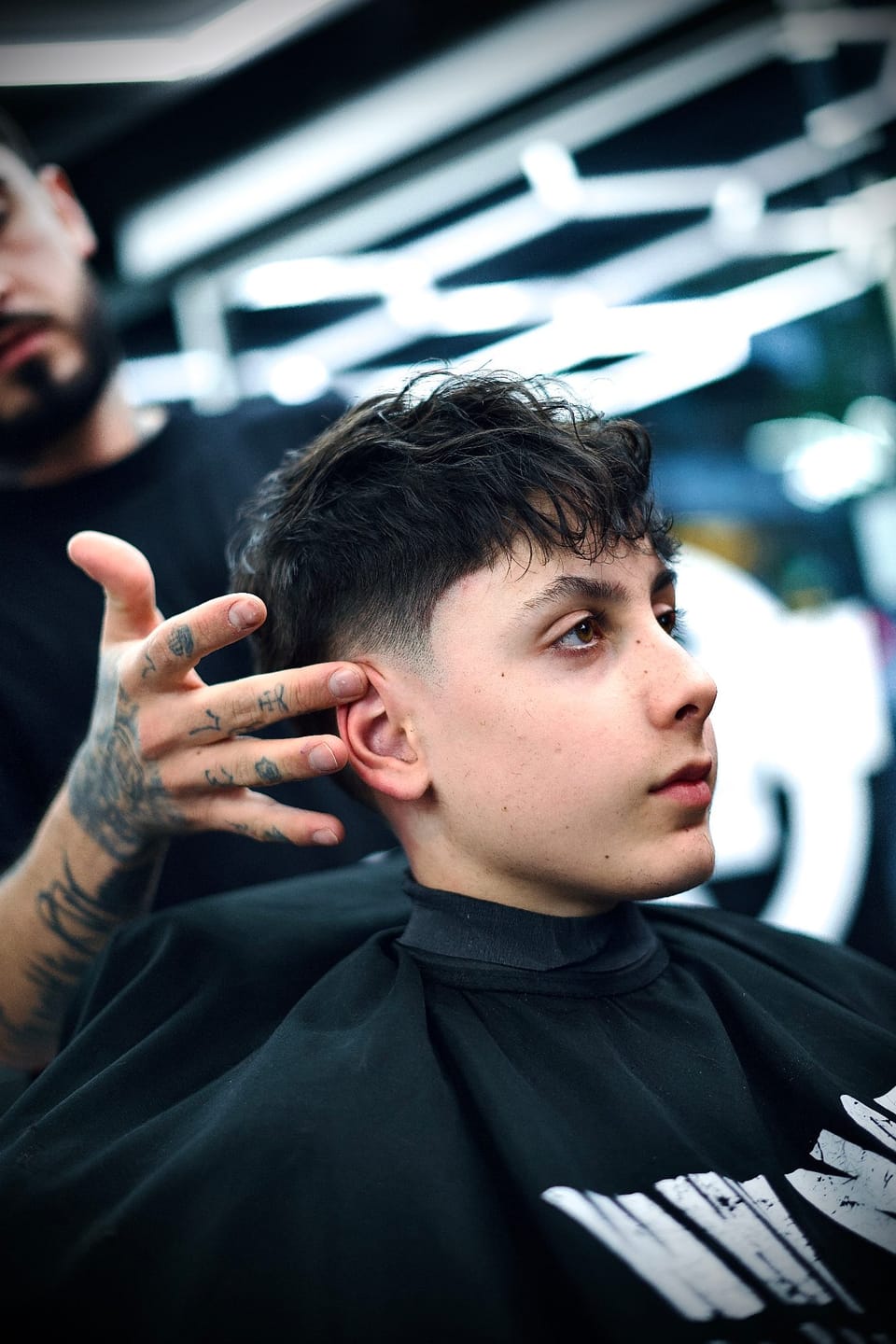 Corte infantil en silla booster en una barbería Why Not